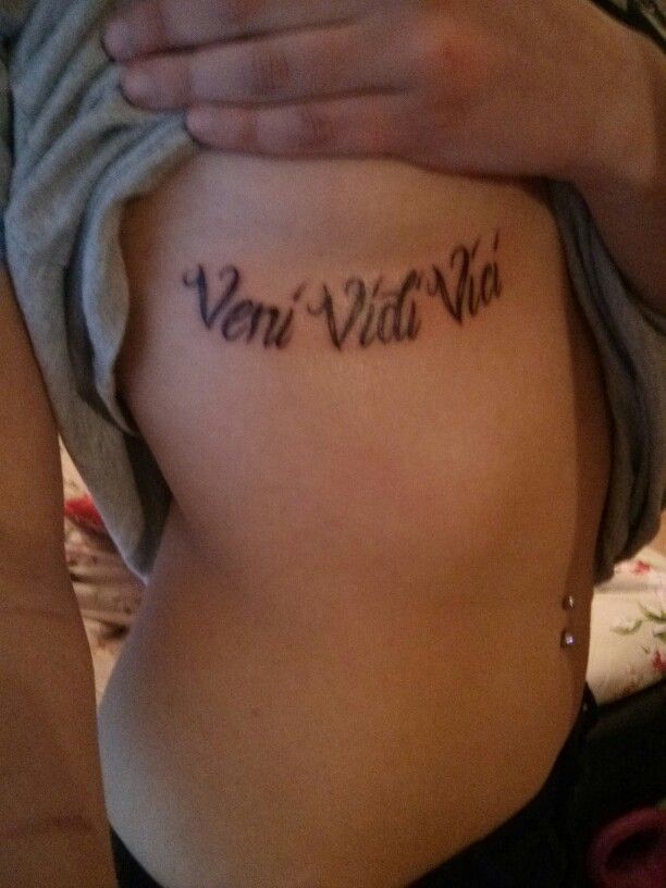 Side tattoo saying Veni vidi vici on Teresa.
